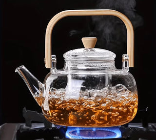 Glass teapot filled with refreshing iced fruit tea with lemons and berries
